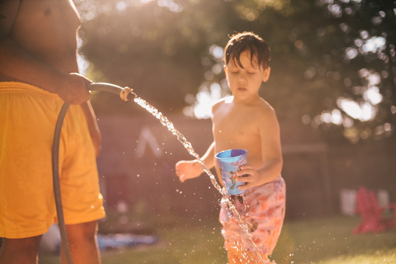 Arizona Best Whole House Water Filter with Kids drinking out of a hose