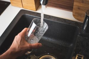 H2O Concepts' water treatment systems help solve Flagstaff Hard Water issues image shows glass being filled from sink