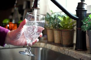 Tackle Wickenburg Hard Water with a filtration system from H2O Concepts image shows glass of water being filled from faucet
