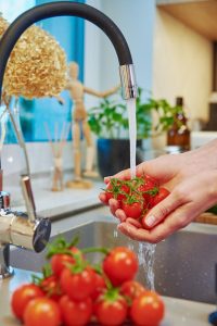 Address Wickenburg Hard Water issues with solutions from H2O Concepts image shows food being washed with faucet