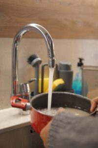 A Tempe Non-Salt Water Softener can provide numerous benefits to your home image shows pot being filled with water at sink