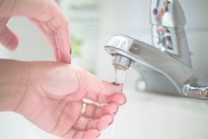 Combat hard water with a Tucson Non-Salt Water Softener image shows hands under faucet