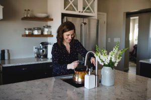 H2O Concepts can help you with Apache Junction Hard Water image shows woman using kitchen sink