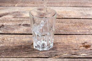 Fix issues caused by Queen Creek Hard Water with help from H2O Concepts image shows glass of water on wooden surface