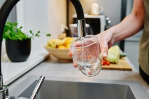 Avoid salt and mess with a San Tan Valley Non-Salt Water Softener image shows glass of water under kitchen faucet